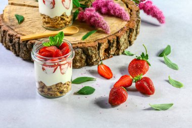 Beyaz ahşap arka planda çilekli katmanlı tatlı, bisküvili kek ve krem peynirli peynir. seçici odak.