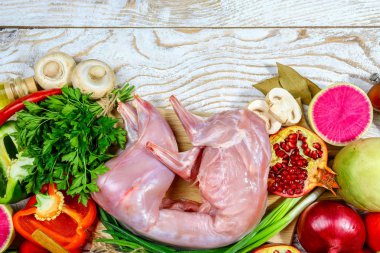 Tavşan pişirmek için hazırlanmış çerçevede. Bulgar biberi, soğan, sarımsak, baharat ve bir sürü sebzenin yanında. Hafif arkaplan. Düz yatış, metin için yer.