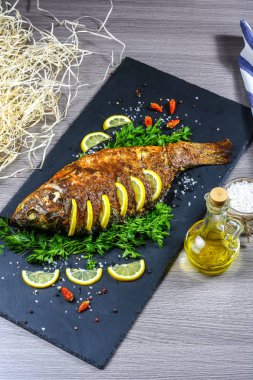 Büyük fırında sazan, otlar, limon ve baharatlar. Üst görünüm, metin için yer. dikey resim.