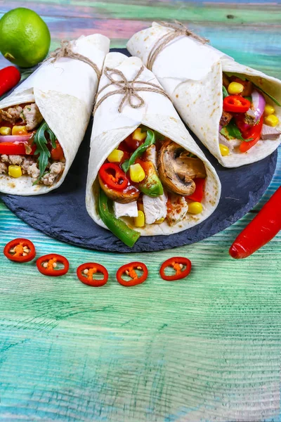 Two beef burritos with beef, avocado beans, and vegetables, salsa, peppers on wooden rustic textures, place for text — Stock Photo, Image