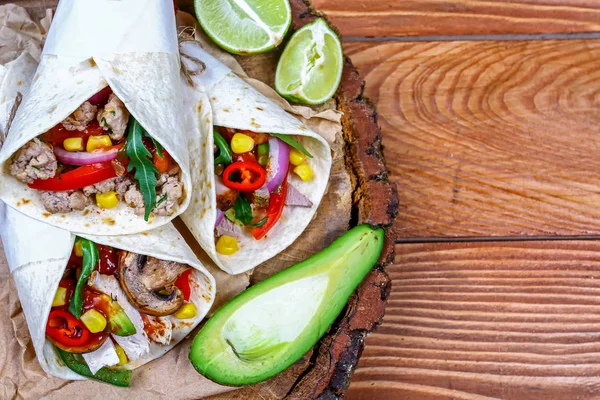 Tasty homemade burrito with vegetables and beef on wooden rustic textures. Mexican restaurant fast food. place for text. top view — Stock Photo, Image