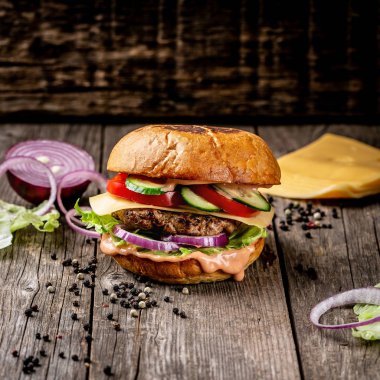 Burger Piled High 'ın Kapanışı Tam Taneli Sanatsal Çörek üzerine Taze Toppings, Kopya Boşluğu ile Rustik Tahta Yüzey.