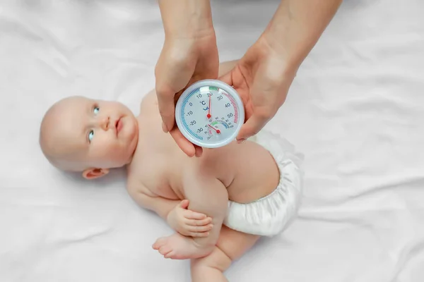 बाळ खोलीत तापमान आणि आर्द्रता तपासणारी स्त्री. संकल्पना इष्टतम हवामान, ओलावा, हवा तापमान — स्टॉक फोटो, इमेज
