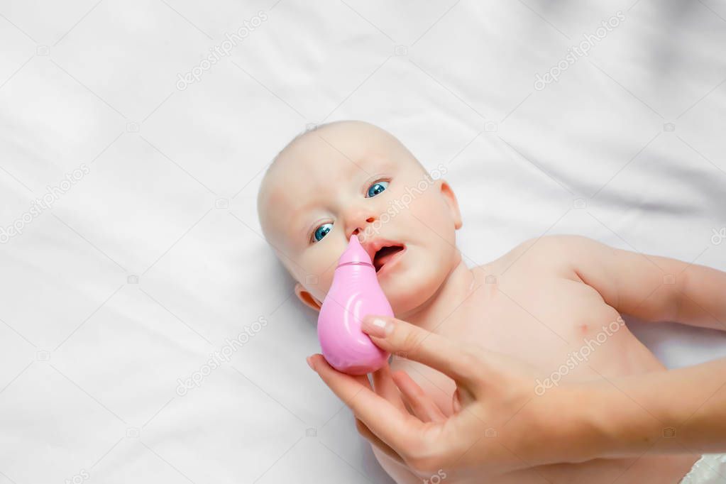 a newborn baby gets noses mucous suctioned with a nose cleaner. concept cleaning wipe, pure