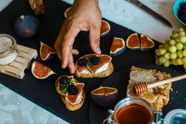 Ricottalı sandviç, taze incir, ceviz ve ballı köy şist tahtası. Üst Manzara. Kahvaltı, öğle yemeği fotoğrafı..