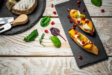 Tatlı mango, nar, camembert peyniri. Hafif ahşap bir arka planda. Sağlıklı yemek, düz manzara..