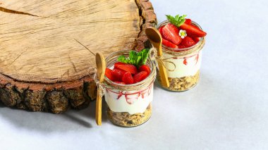 Beyaz ahşap arka planda çilekli katmanlı tatlı, bisküvili kek ve krem peynirli peynir. Boyama. Düz yatıyordu. Boşluğu kopyala.