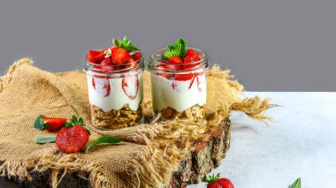 Sağlıklı katmanlı yoğurt, bisküvi, ahşap arka planda çilek, boş alan..