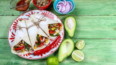 Taco - Meksika mutfağının geleneksel çanak. Et, sebze ve sos ahşap zemin ile Meksika Taco. Üstten görünüm.