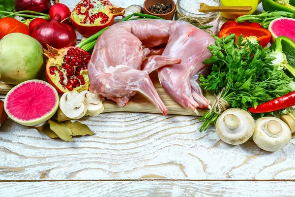 Rabbit rabbit meat with vegetables on wooden table background. Homemade traditional cuisine recipe. Flat view, overhead. vertical image.