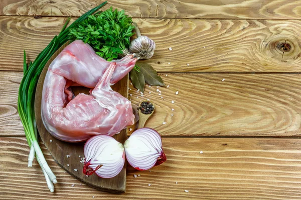 Rabbit rabbit meat with vegetables on wooden table background. Homemade traditional cuisine recipe. Flat view, overhead. Top view, free space for text.