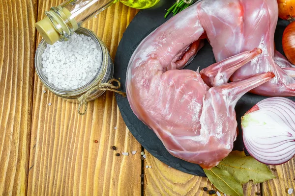 Maydanoz ve baharat çiğ tavşan etli ahşap arka plan üzerinde bir daire içinde ortaya koydu. Arka plan yemek. Üstten görünüm, metin için boş alan.