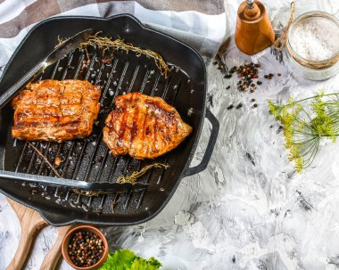 Biftek yemeye hazır, otlu ve tereyağlı demir tavada. Akşam yemeği için hazır yemek. Kopyalama alanı olan üst görünüm.