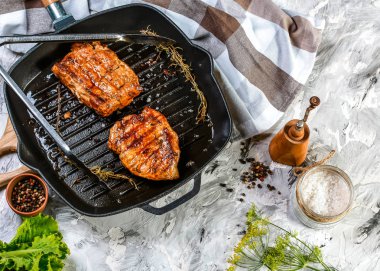 Tahta kesme tahtasının üzerinde demir tavada baharatlı ızgara biftek. Metnin için kopyalama alanı olan üst görünüm.