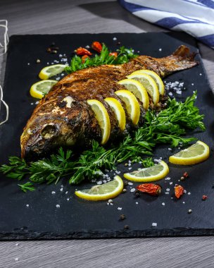 Büyük fırında sazan, otlar, limon ve baharatlar. Üst görünüm, metin için yer. ev yemeği konsepti.