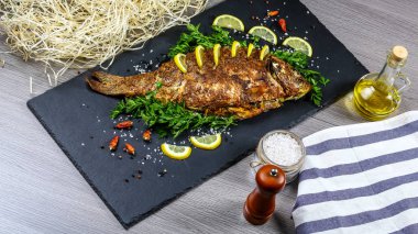 Large baked carp with herbs, lemon and spices. flat top view, copy text menu. clipart