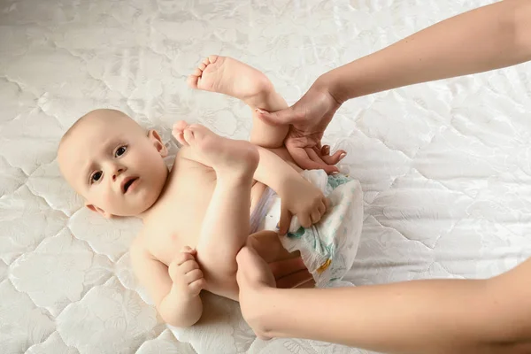 母親はオムツを新生児に変えます 日常生活の中で 家族のライフスタイル 赤ちゃんの衛生状態は湿っていて — ストック写真