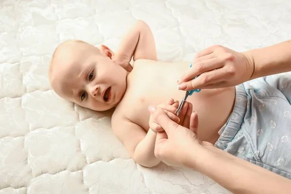 手で赤ちゃんのための爪と指のマニキュアお母さんは愛とケアできれいに爪を切るために小さなはさみを保持しています 新生児ケアの概念は — ストック写真