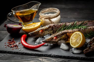 tuz, yağ ve otlar, tüm biber, çiğ balık pike hazırlanması düzenlendiği rustik koyu arka plan üzerinde Doğrama tahtası. Metin üstten görünüm alanı olan sınır.