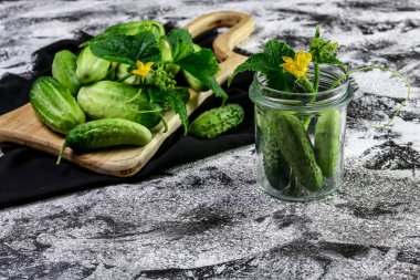 Mevsimlik yeşil Mini salatalıklı yeşil yapraklı ve çiçekli koyu arkaplan.