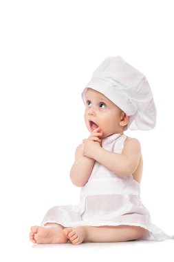 10 aylık bir bebek aşçı kıyafetiyle mutfakta şaşırdı ve gülümsedi. Küçük bir çocuk aşçı ya da sincap kostümü içinde pizza yapar. Çocuk hayatı pişirme konsepti. Yürüyen çocuk oynuyor.