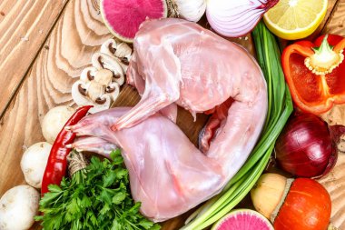 Tavşan leşi, sebzeli çiğ et, ahşap zeminde tuz ve maydanoz. üst görünüm ve boş yer.