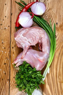 Tahta üzerinde çiğ tavşan ve ahşap arka planda malzemeler. en üstteki görünüm.