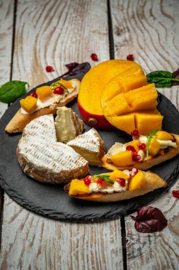 Peynir tabağı yakın plan. Lezzetli kızarmış ekmek ve mango. Mangolu fırça, Camembert peyniri.