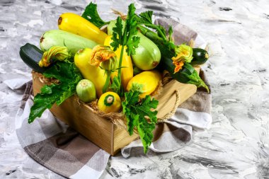 Tahta bir kutuda çiçekli taze kabak. Yaklaş, yaz kabağı. metin için yer