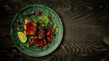 Baharatlı böğürtlen soslu biftek ve tabağında yeşil fidanlarla servis edilen pirzola. Alanın Sığ Derinliği. Asya mutfağı kavramı. Restoran servisi. Üst görünüm, metin için yer