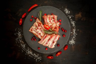 Kil tahtasında çiğ pirzola, arka planda. Otel servisi ve restoran yemekleri konsepti. Üst görünüm, metin için yer