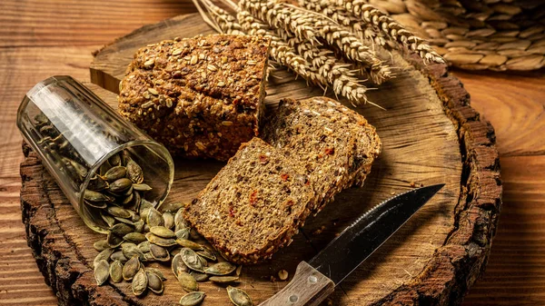 Концепція здорового харчування. Цілий зерновий хліб з насінням ягід годзі, гарбуза, на тарілці на дерев'яному фоні — стокове фото