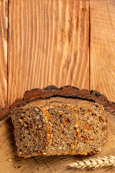 Krájený žitný chléb na řezací desce. Celozrnný žitný chléb se semínky goji bobulí. zdravá výživa. Mezera pro text. pohled shora — Stock fotografie