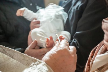 Bebek vaftiz töreni. Vaftiz törenine hazırlanmak, beyaz battaniyenin üzerinde bacaklar, bebeği Ortodoks kilisesinde vaftiz etmek.