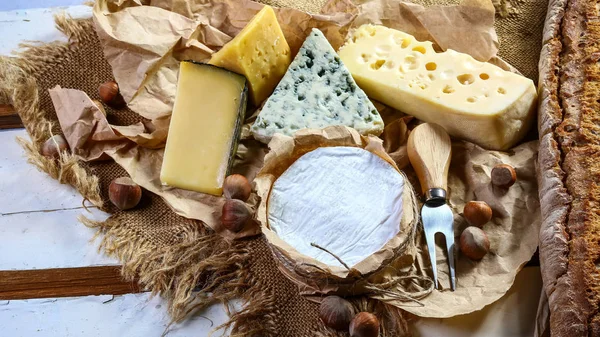 Queso italiano surtido, queso con moho azul, Camembert o círculo de queso brie y nueces, cuchillo de servir queso. vista superior, espacio de copia — Foto de Stock
