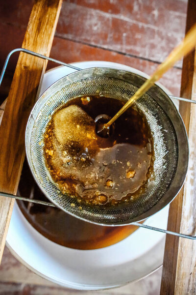 Крупный план разворачивания пчеловода. процедить мед через решето из медового горшка. Крупный план разворачивания пчеловода. Концепция пчеловодства