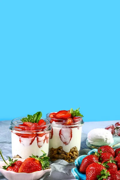 strawberries with whipped cream dessert in the glass on a blue background. Copy space
