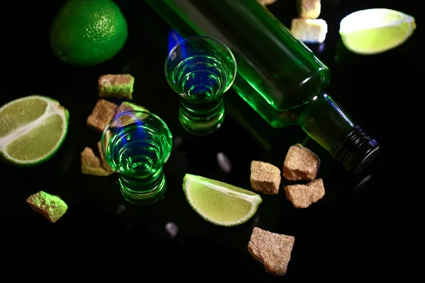 Absinth in ein Glas gegossen. Absinth-Shots mit Zuckerwürfeln. Flasche Absinth und Gläser mit brennendem Inhalt. Freiraum für Text. das Konzept des Elitealkohols — Stockfoto