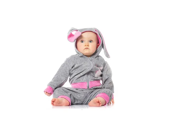 Mignon petit bébé en costume de lapin assis sur fond blanc. jeux pour enfants. émotions de bébé — Photo