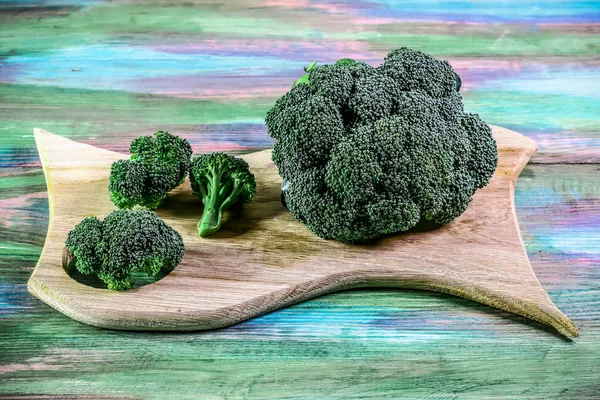 Hälsosam eller vegetarisk mat koncept. Färsk grön broccoli på en träskiva, rustik trä bakgrund. Ovanifrån, plats för text — Stockfoto