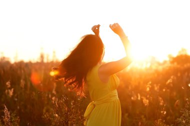 Güzel esmer bayan güzel gün batımına bakıyor. Yakın plan portre