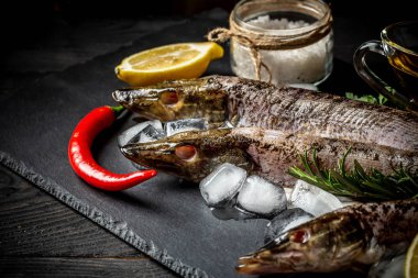 Ham nehir balık ve sebze siyah ahşap zemin bir rustik tarzda yemek pişirmek için. Üstten Görünüm.