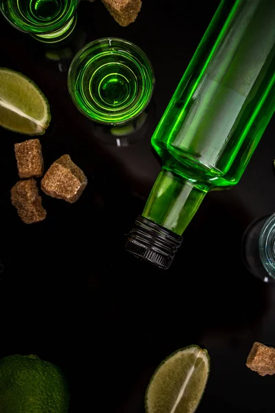 Absinthe en verre avec tranches de lime, cubes de sucre sur fond sombre. vue du dessus, espace pour le texte — Photo