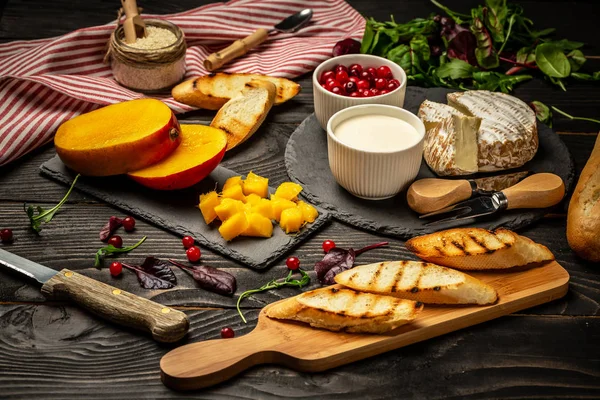 Toasts of cheese, Alphonso mango. Bruschetta with mango and cheese. Homemade. Healthy vegetarian nutritionon a wooden background, Top view. Copy space — Stock Photo, Image