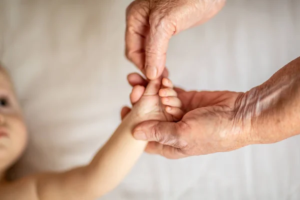 Handen van de jonge achterkleinzoon en de oude overgrootmoeder. Happy Family concept. Mooi conceptueel beeld van moederschap. selectieve focus — Stockfoto