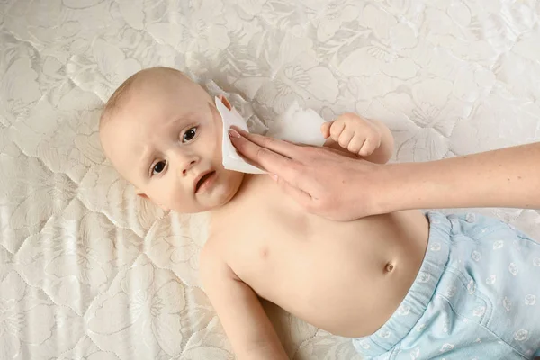 Cuidado materno del bebé: limpiar la piel del bebé con toallitas húmedas. emociones de bebé graciosas. Higiene del cuidado del bebé. Limpieza de toallitas, puro, limpio —  Fotos de Stock