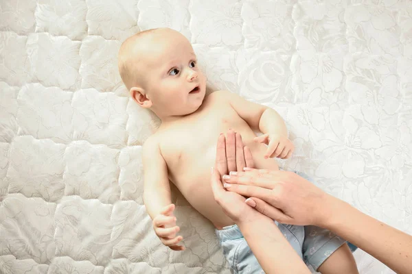 Madre hace masaje para el bebé feliz, aplicar aceite en la mano, concepto de familia feliz. Hermosa imagen conceptual de la maternidad —  Fotos de Stock