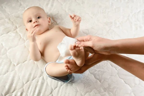 Primer plano en la mano de la madre y el niño cuidado del cuerpo con enfoque en limpiar la nalga del bebé. Concepto de familia feliz. Hermosa imagen conceptual de la maternidad —  Fotos de Stock