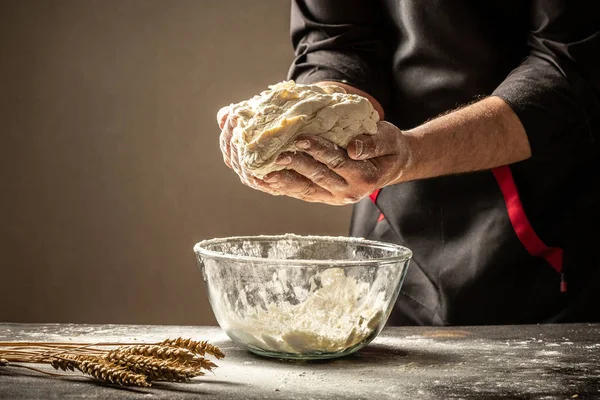 An experienced chef in a professional kitchen prepares the dough with flour to make the bio Italian pasta. the concept of nature, Italy, food, diet and bio. Food concept