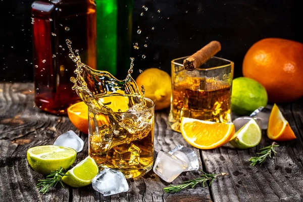 Bebida de élite para la relajación masculina Dos vasos de whisky, ron y cigarro para fumar, hielo sobre fondo negro, espacio para copiar. concepto bebida de lujo — Foto de Stock